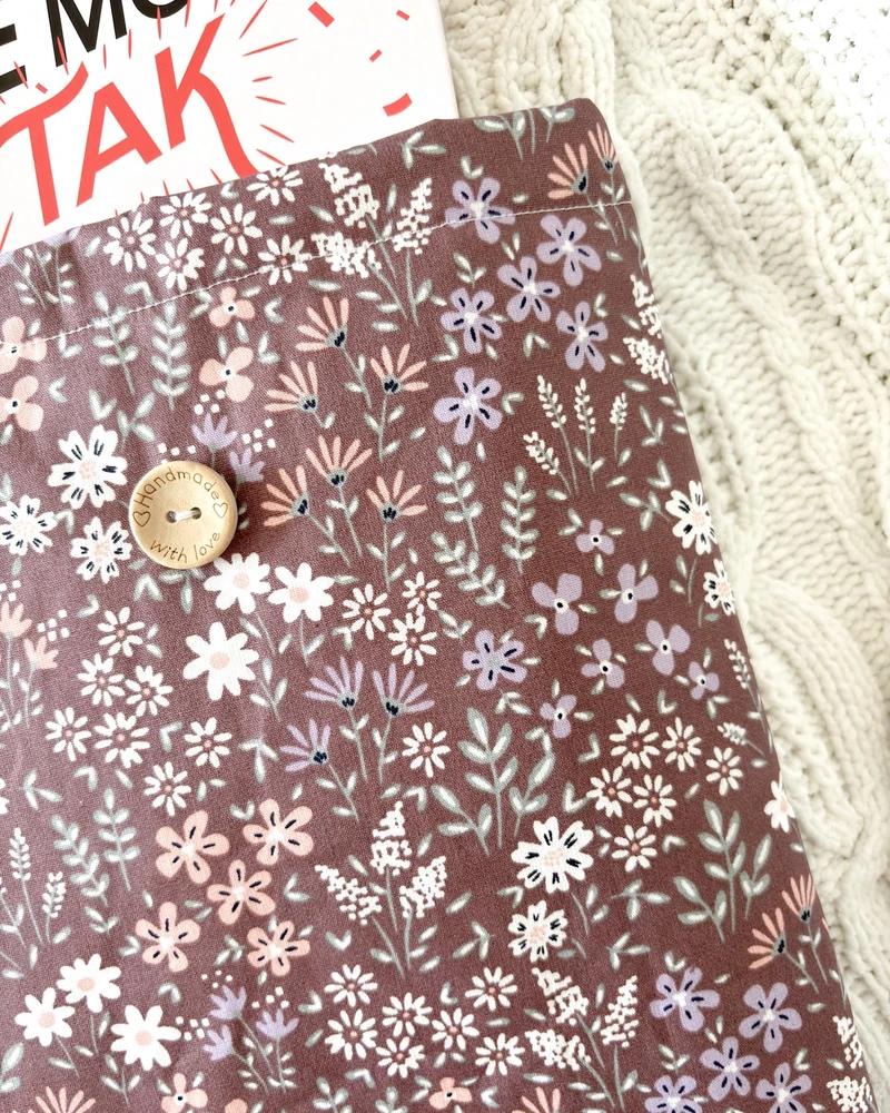 Booksleeve w brązowo-bordowym kolorze z drobnym wzorem w kwiaty, zbliżenie na detale
