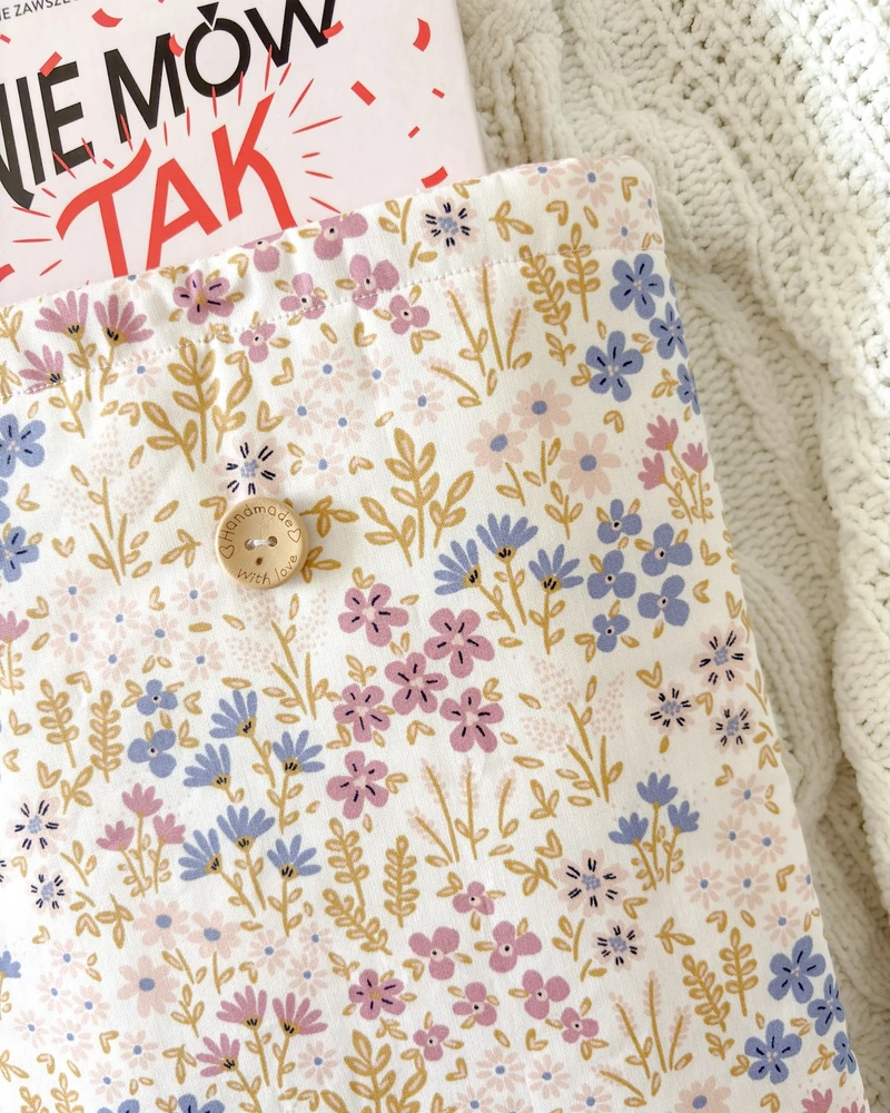 Booksleeve w kremowym kolorze ze wzorem w kwiaty polne, zbliżenie na detale